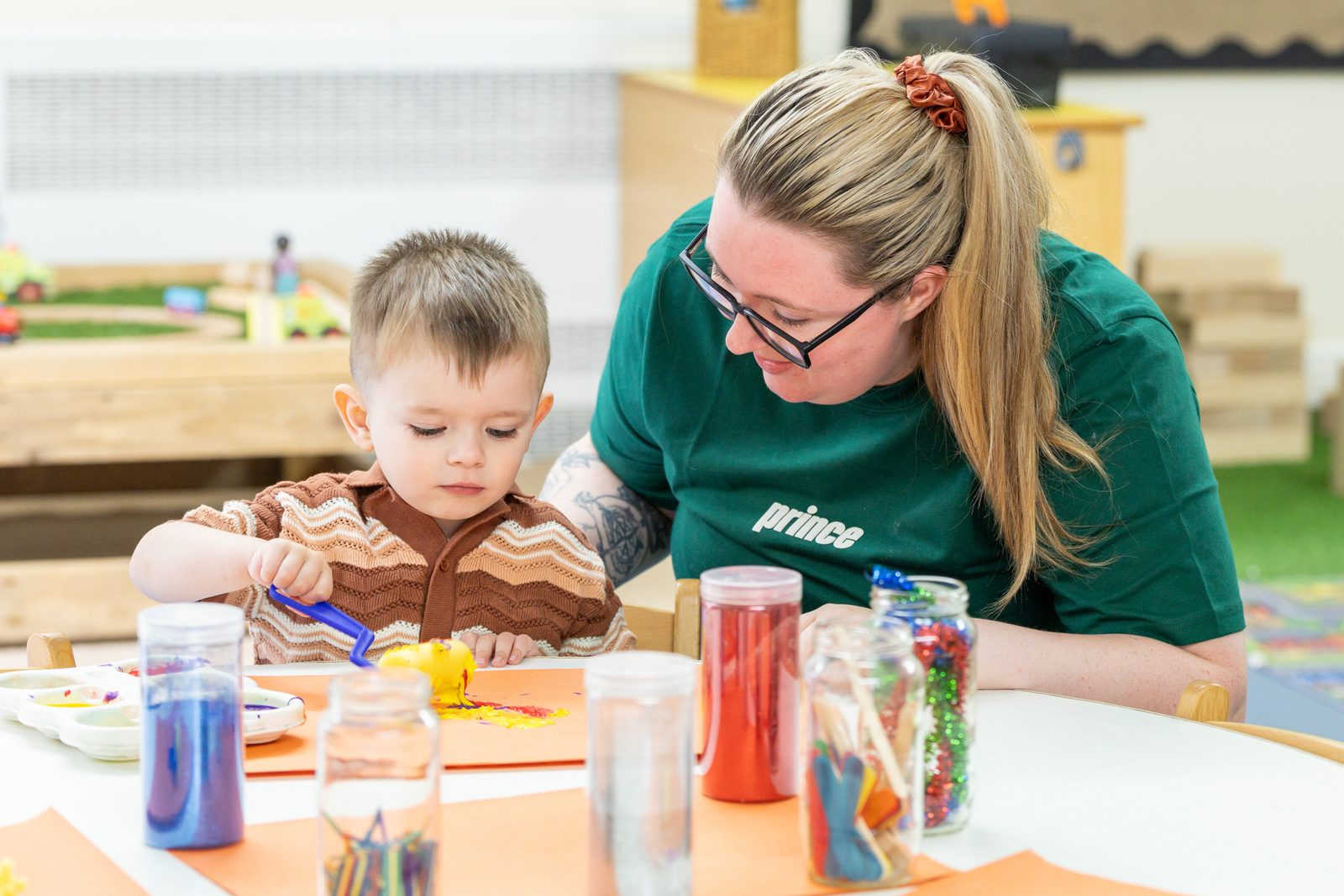 A practitioner and child painting together